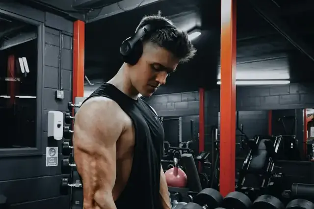 Muscular man in a sleeveless top in a gym