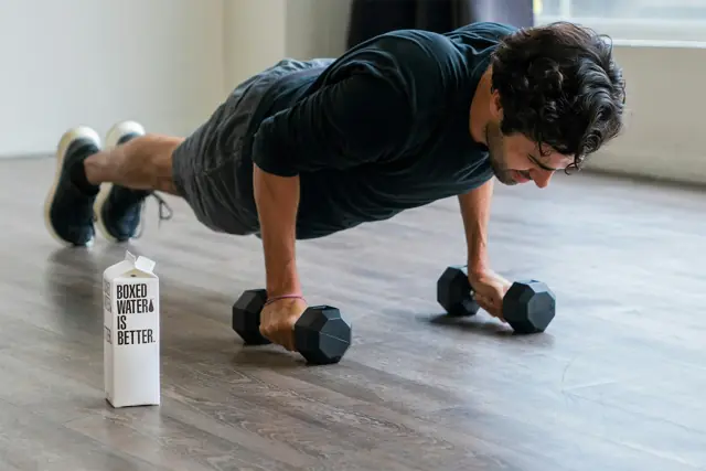 Man doing push-ups on dumbbells at home
