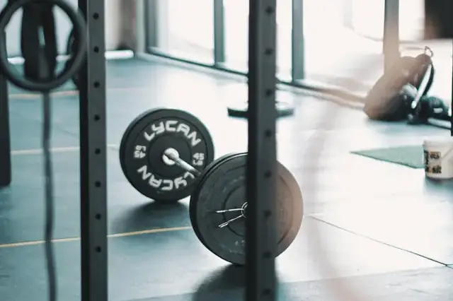 Barbell loaded with weight plates in a rack