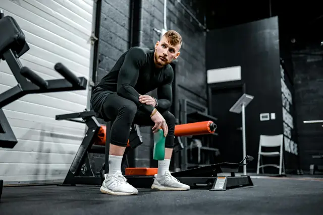 Man resting on a bench between sets